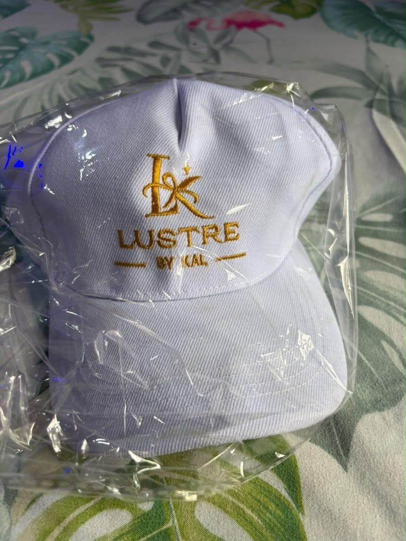 White cap embroidered with the Lustre by Kal logo