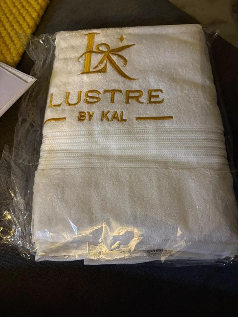 White towel embroidered with the Lustre by Kal logo